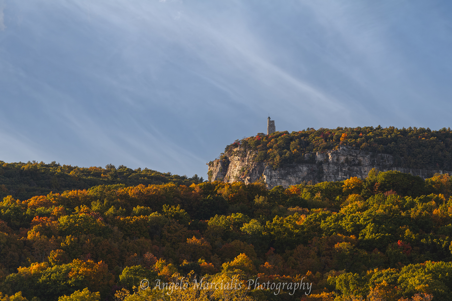 Mohonk Mountain House Sky Top Tower overlooking autumn foliage and dramatic cliffs in the Shawangunk Ridge, Hudson Valley, New York landscape photograph.